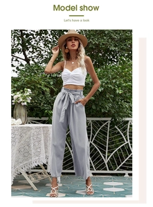 Détail du pantalon taille haute à cordon avec un haut court débardeur blanc cintré
