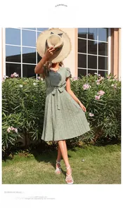 Détail d'une robe fleurie verte avec ceinture nouée et manches à volants