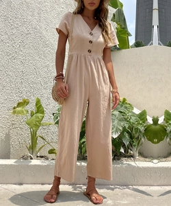 Dettaglio tuta beige con scollo a V, bottoni, vita elasticizzata e trama in lino