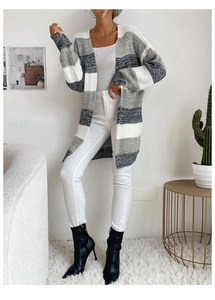 Detail of a long-sleeved knit cardigan with grey and white striped patchwork pattern