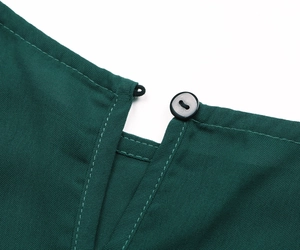 Detail of dark green dress neckline with button closure and refined white topstitching