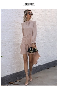 Detail of high neck dress with ruffle sleeves and asymmetrical high-low hemline in apricot