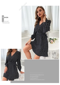 Detail view of black and white polka dot wrap dress with V-neckline and ruffled hem