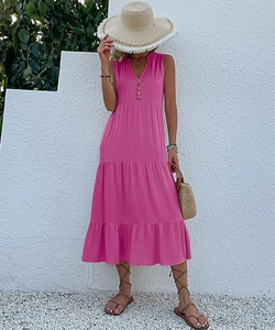 Close-up of a hot pink V-neck tiered midi dress featuring classic wooden button details