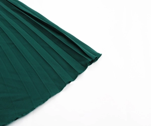 Detailed view of the dark green pleated chiffon hem with professional rolled edge stitching