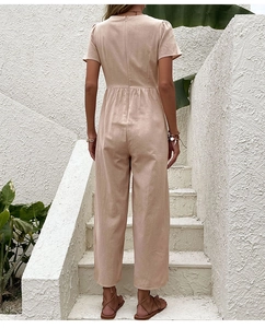 Dettaglio della zip posteriore e della vita a pieghe su una tuta beige a gamba larga
