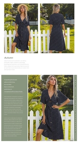 Detail of navy blue polka dot midi dress with V-neck, cutout knot, and side slit design