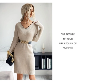 Detail view of beige knit dress with black lace trim V-neck and stylish waist belt
