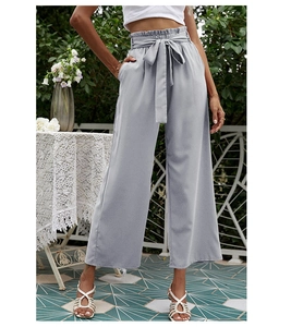 Détail du pantalon large à taille haute avec ceinture assortie et plis élégants
