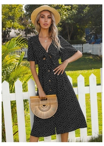 Detail of black polka dot midi dress with deep V-neckline and decorative front bow tie