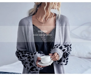 Close-up of women's knit cardigan with leopard print cuff details and lace top layers
