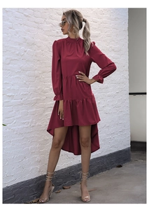 Detail of burgundy high-neck dress showing ruffled cuffs and tiered irregular hemline