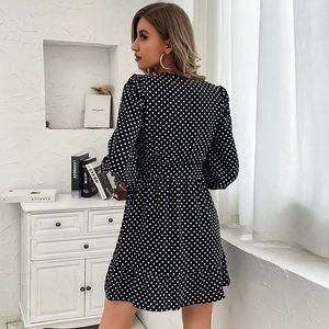 Elegant black long-sleeved polka dot dress with waist tie and ruffled hemline