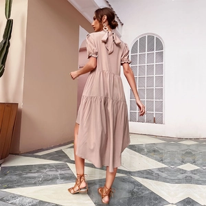 Elegant mauve puff sleeve tiered midi dress with back bow tie detail in outdoor setting