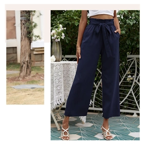 Détail d'un pantalon bleu marine à taille haute, coupe large avec ceinture nœud papillon