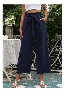 Détail du pantalon bleu marine à taille haute, jambes larges et nœud à la ceinture
