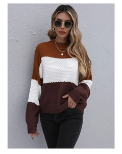 Detail of three-tone color block knit sweater with caramel, white, and dark brown segments