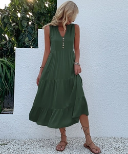 Close-up of the V-neckline with light buttons and tiered skirt on a dark green dress