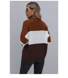 Detail of color-block knit sweater featuring textured diamond patterns and chunky soft fabric