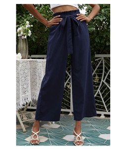 Détail du pantalon large bleu marine à taille haute avec une ceinture à nœud élégant