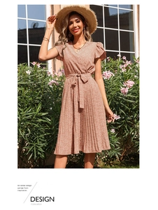 Détail de la robe fleurie rouge brique avec col en V, ourlet plissé et ceinture assortie