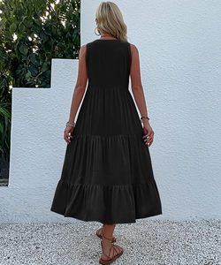 Detail view of the tiered layers and pleated design on a black sleeveless maxi dress