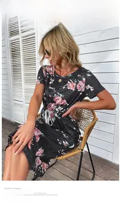Détail d'une robe d'été noire avec motifs de roses roses et taille à cordon