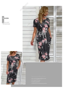 Détail d'une robe d'été gris foncé avec motif de roses roses et cordon de serrage à la taille