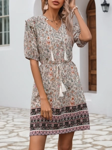 Close-up of bohemian floral dress showing V-neck tassel ties and ethnic geometric hem details