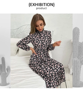 Detail of floral long sleeve midi dress with high collar and cinched waist on a model