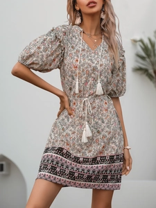 Detail of bohemian V-neck floral dress with white tassels and ethnic geometric patterns