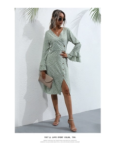 Detail of light green floral dress featuring V-neck wrap design and ruffled sleeve cuffs