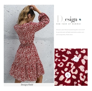 Dettaglio dell'abito rosso con stampa leopardata, bottoni bianchi e orlo a balze