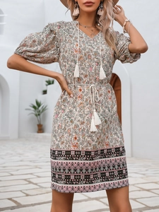 Detail of V-neck floral dress with bohemian tassels and elegant lantern sleeves