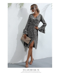 Detail of V-neck wrap dress with polka dots, ruffled trumpet sleeves and side buttons