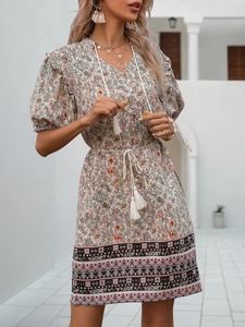 Detail of floral bohemian dress featuring tassel drawstring waist and geometric hem