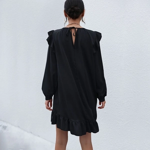 Elegant black long sleeve dress with ruffle hem and back tie detail in Audrey Hepburn style