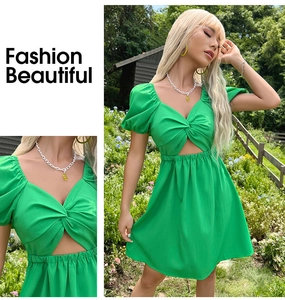 Détail du nœud au col en V et découpe à la taille sur cette robe verte à manches bouffantes