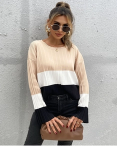 Détail d'un pull en maille color-block avec côtes verticales et manches cloches