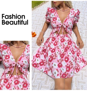 Détail de robe fleurie rose avec col en V à volants, taille évidée et design lacé devant