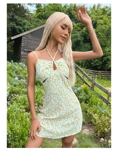 Détail d'une mini robe fleurie vert clair avec col licou et découpe à la taille sexy