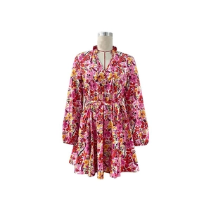 Détail du col en V avec volants et imprimé floral sur une robe à ceinture