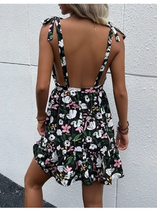 Detail of floral backless dress showing bow shoulder straps and ruffled hem design