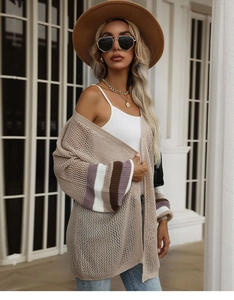 Detail of hollow knit texture on beige cardigan with striped cuffs and loose fit