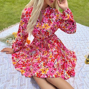 Robe trapèze à fleurs manches longues avec col en V et ceinture sur tapis de pique-nique