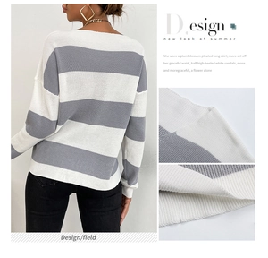 Détail du pull en maille rayé gris et blanc montrant les poignets côtelés et la texture