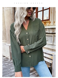Detailed macro view of olive green blouse with chest pocket and textured fabric finish