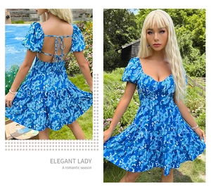 Détail de mini robe fleurie bleue avec dos nu à lacets et volants superposés élégants
