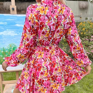 Robe fleurie à manches longues pour femme avec ceinture et col en dentelle dans un jardin