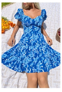 Détail d'une robe d'été fleurie bleue avec manches bouffantes et décolleté en cœur